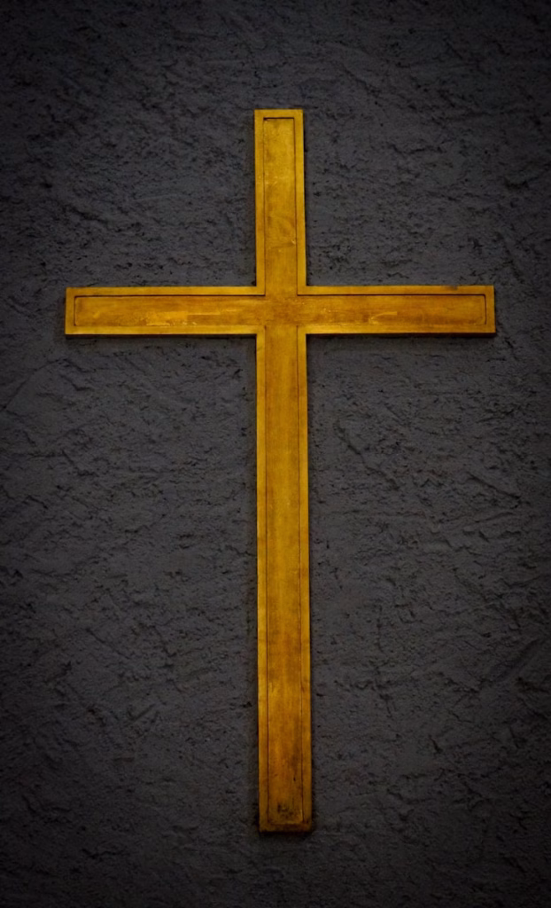 a yellow cross on a black wall