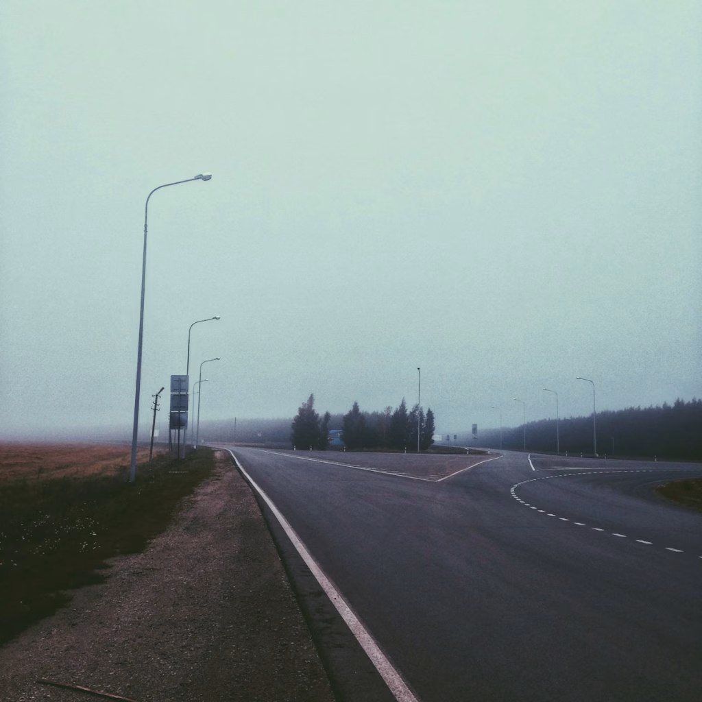 a foggy road in the middle of a rural area